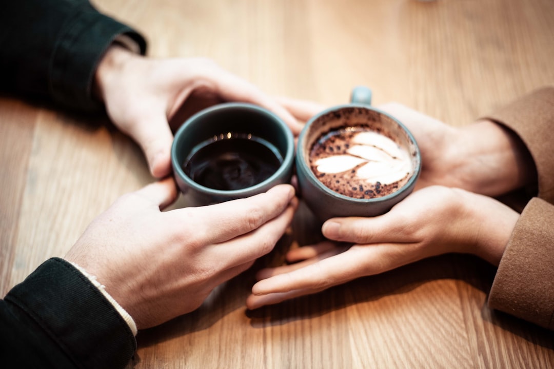 コーヒーカップを手にする二人の手元-ヘッダー画像-