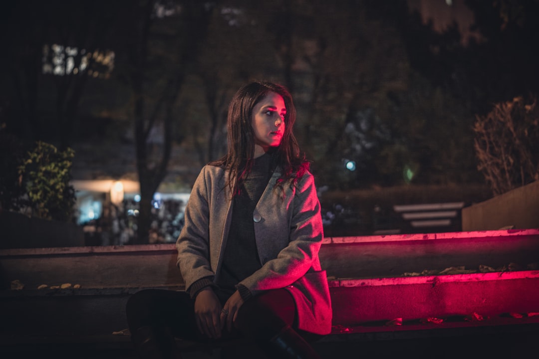 窓辺でスマートフォンを見つめながら物思いにふける女性-ヘッダー画像-
